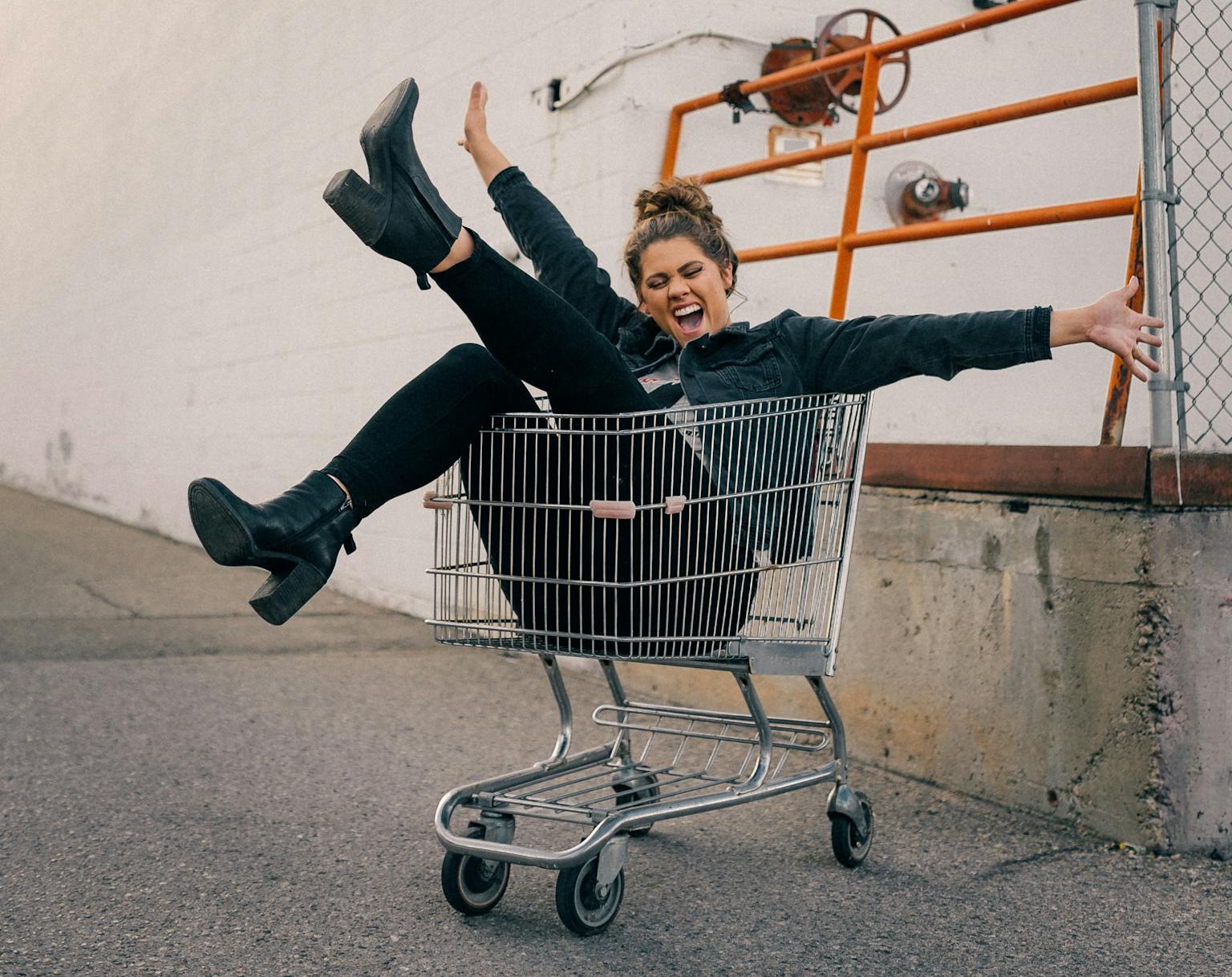 Lachende Frau in Einkaufswagen